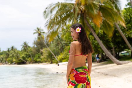 Tahiti luxury travel beach vacation woman walking in cover-up skirt on island, French Polynesia. Image is completely unretouched and model is without makeup. Authentic real people. Original Raw Image.