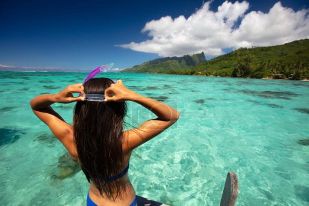 Beach travel vacation sport girl ready to snorkel in coral reefs of turquoise waters in Tahiti, French Polynesia. Image is completely unretouched. Authentic real people. Raw Image.