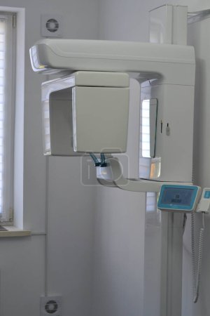 Foto de El tomógrafo X-View Trident Dental está en una oficina luminosa. Clínica dental moderna. Equipos médicos modernos en el hospital. - Imagen libre de derechos