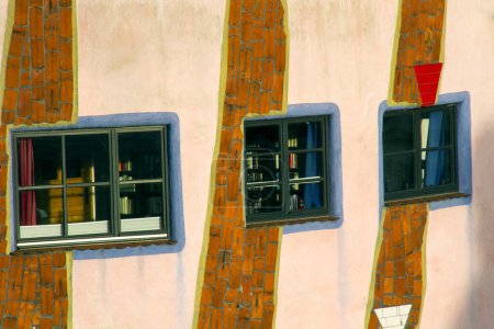 Foto de 16 de diciembre de 2023: Hundertwasser casa de arquitectura orgánica llamada "gruene Zitadelle" en Magdeburgo, Sajonia-Anhalt, Alemania. Ampliar detalle en tres ventanas de la pared rosa. Cerca de un piso. - Imagen libre de derechos