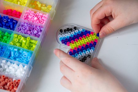 Set of perler beads. Perler pegboard, tweezers and many colorful fusible beads. Toy that develops the imagination of child. Childrens toys theme. Wide background with copy space