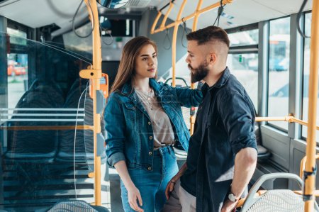 Couple standing in a moving bus and talking while flirting