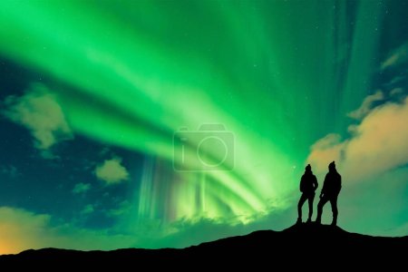 Une silhouette de jeunes couples aventureux observant les aurores boréales également appelées aurores boréales. Photo de haute qualité