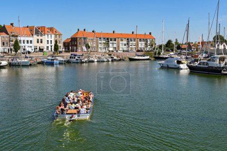Photo for Middleburg, Netherlands - August 2022: Tourist sightseeing cruise boat sailing on the harbour near the city centre - Royalty Free Image