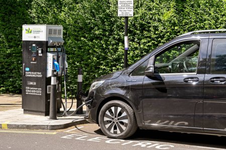 Photo for London, England - June 2022: Private electric vehicle plugged into a rapid charging point on a street in central London - Royalty Free Image