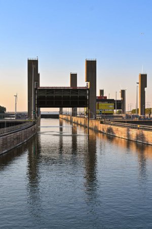 Foto de Rilland, Países Bajos - agosto de 2022: Entrada a una gran esclusa de canal al atardecer con la puerta de esclusa levantada para permitir que los buques entren - Imagen libre de derechos