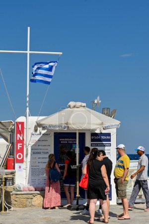 Photo for Mykonos, Greece - June 2022: People queuing to buy ferry tickets at the ticket kiosk on the harbour in the town of Mykonos - Royalty Free Image