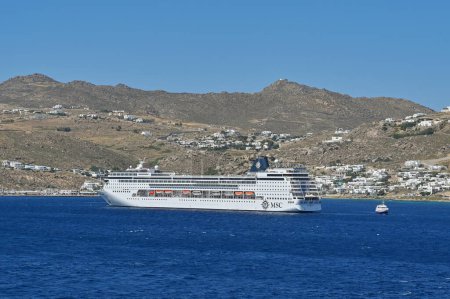 Foto de Mykonos, Grecia - Junio 2022: Crucero Armonia fondeando frente a la costa de la isla griega de Mykonos. El barco es operado de MSC Cruises - Imagen libre de derechos