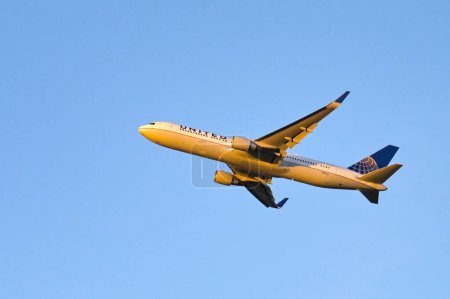 Téléchargez les photos : Londres, Royaume-Uni - Février 2023 : Le Boeing 767 de United Airlines (immatriculé N686UA) grimpe après le décollage au crépuscule contre un ciel bleu clair - en image libre de droit