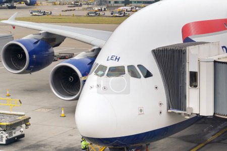 Foto de Londres, Reino Unido - febrero de 2023: British Airways Airbus A380 jet (registro G-XLEH) con equipo de carga de palets de carga aérea junto a la puerta abierta de su bodega de carga - Imagen libre de derechos