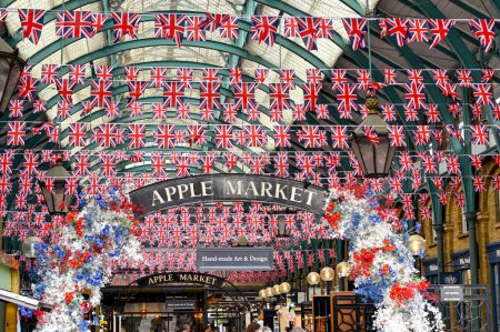 Téléchargez les photos : Londres, Angleterre - Juin 2022 : Marché aux pommes intérieur au Covent Garden de Londres avec des rangées de drapeaux Union Jack accrochés au toit - en image libre de droit