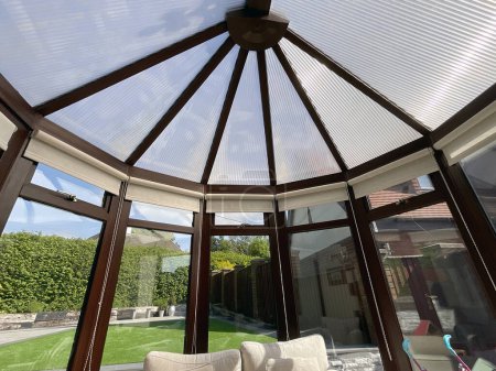 Photo for Cardiff, Wales - May 2023: Wide angle view of the conservatory overlooking the garden of a home on the outskirts of Cardiff - Royalty Free Image