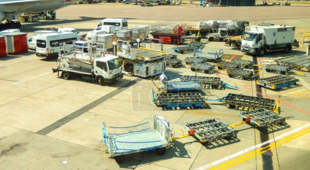 Photo for London, England, UK - 14 June 2023: Vehicles and ground handling equipment for air cargo at at one of the terminals at Heathrow airport. In the background are passenger jets. - Royalty Free Image