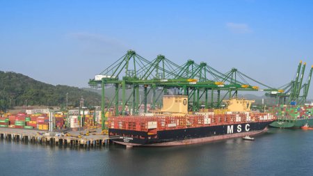 Photo for Panama City, Panama - 23 January 2024: Wide angle view of cranes unloading the container ship MSC Cassandre docked in the port of Panama City - Royalty Free Image
