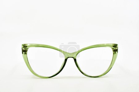 Pair of cat eye shape glasses with green frames isolated on a plain white background. Copy space. Eyesight concept.