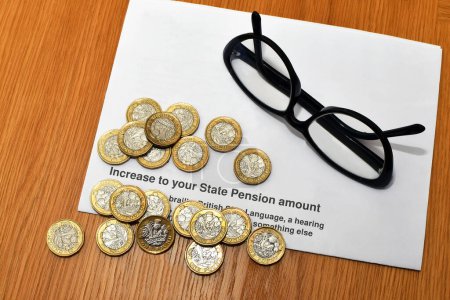 Britische Ein-Pfund-Münzen in einem anonymen Brief über eine Erhöhung der staatlichen Rente in Großbritannien