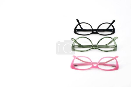 Photo for Pairs of glasses with pink, green and black frames in a row isolated on a plain white background. Copy space to left. Eyesight concept. - Royalty Free Image
