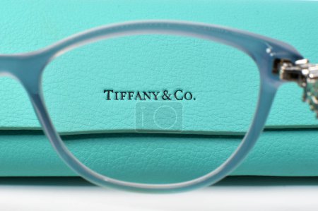 Photo for Cardiff, Wales - 9 March 2024: Close up view of a glasses case mae by Tiffany and Co. seen through the lens of a pair of Tiffany glasses with a blue frame - Royalty Free Image