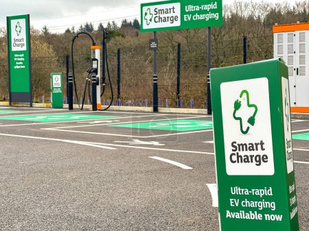 Foto de Pontyclun, Gales - 21 de marzo de 2024: Punto de carga rápida para vehículos eléctricos en el aparcamiento del supermercado. - Imagen libre de derechos