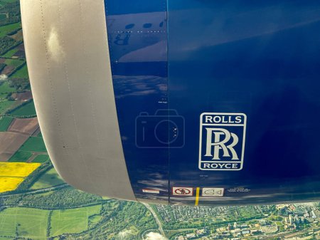 Photo for En route USA to UK - 4 May 2024: Rolls Royce turbofan jet engine on an airliner flying over land - Royalty Free Image