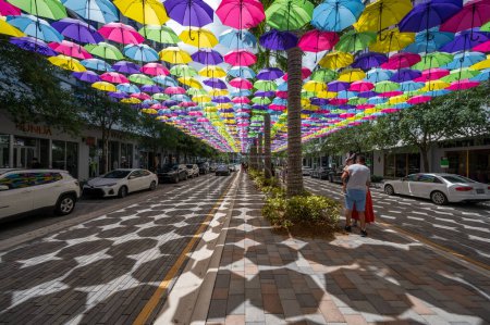 Photo for Doral, Florida - April 9, 2023 - Visitors enjoy canopy of colorful umbrellas suspended over Doral CityPlace boulevard on sunny sunday morning. - Royalty Free Image