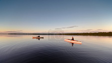 Photo for Two kayakers on calm water of Coot Bay in Everglades National Park, Florida at sunset. - Royalty Free Image