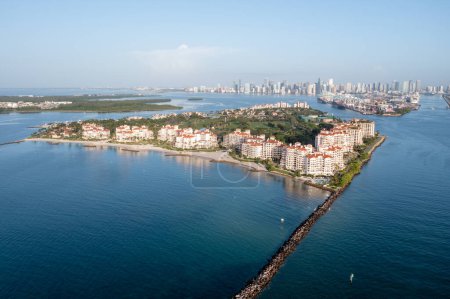Photo for Aerial view of Fisher Island at sunrise with City of Miami skyline and Port Miami in background on calm clear summer morning.. - Royalty Free Image