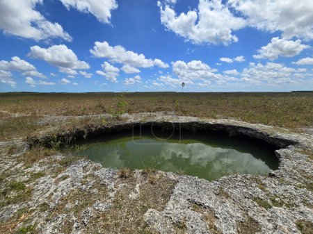 Sonnige Sommerwolkenlandschaft über dem Lösungsloch im Everglades National Park, Florida, spiegelt sich in ruhigem Wasser.