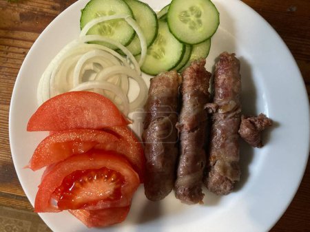 Cooking cevapchichi the Balkan meat sausages