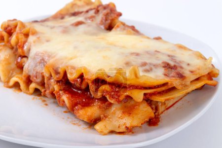 Photo for Close-up of a Delicious baked lasagna part over white background - Royalty Free Image