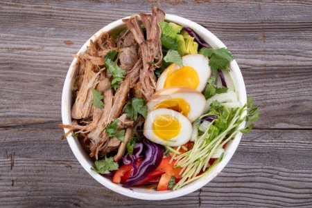 Photo for Delicious pulled pork loaded ramen bowl dish closeup with veggies and boiled eggs - Royalty Free Image