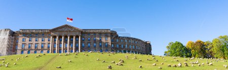 Photo for Look upon the hill to the Wilhemshoehe Castle in Kassel, Germany, there is a flock of sheep in the meadow in front of it, panorama - Royalty Free Image