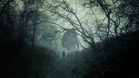 Un concepto oscuro y atmosférico de un enorme monstruo de pies grandes. Siluetas en un bosque. Con una persona mirándolos. En un espeluznante y nebuloso día de inviernos.