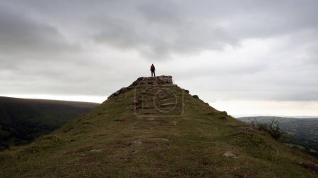 Photo for A hiker on top a hill. Surrounded by hills and countryside. On a bleak winters day. Brecon Beacons. UK - Royalty Free Image