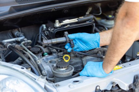 Ignition coil change or replacement. Repairing of vehicle engine.