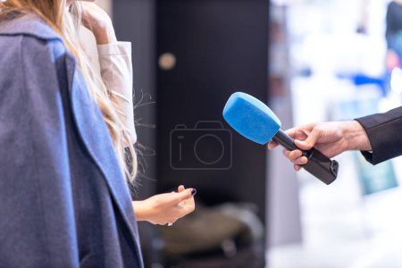 Foto de Periodista de noticias entrevistando a una mujer irreconocible - Imagen libre de derechos