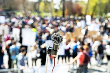 Photo for Protest or public demonstration, focus on microphone, blurred crowd of people in the background - Royalty Free Image