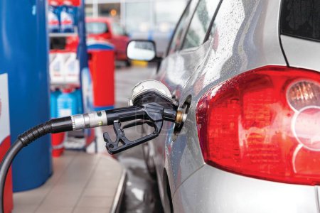 Fill up a car with petrol or diesel fuel at gas station 