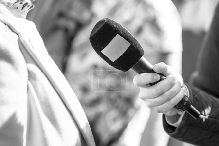 Foto de Reportero sosteniendo micrófono haciendo entrevista a los medios. Concepto de Vox populi. - Imagen libre de derechos