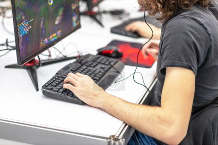Joueur méconnaissable jouant en ligne jeu vidéo d'ordinateur. Concept de dépendance au jeu vidéo.