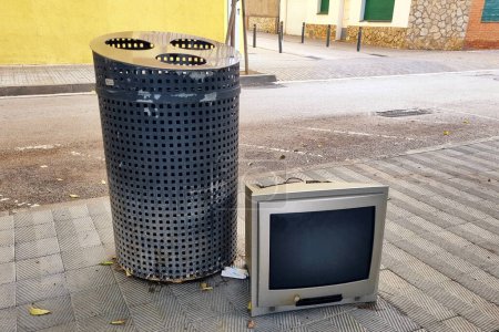 Photo for Broken old crt tv near a metal trash can on city street. Problem of urban pollution concept. - Royalty Free Image