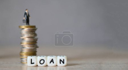Loan Business Economy Konzept von Geld und Finanzen, auf dem Tisch, Loan Business Finance Economy und Geschäftsmann stehen auf einer Münze auf Holztischhintergrund