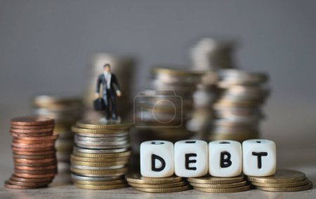 Schulden Business Economy des Geldes und Finanzierung Wort Schulden auf Münzen mit Geschäftsmann, Zahlung von Steuern und Schulden an den Staat, Konzept der finanziellen 