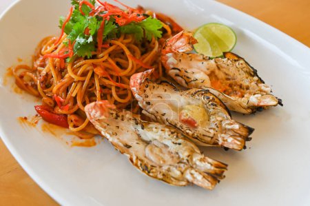Photo for Noodles plate with spaghetti pasta stir fried with vegetables herb spicy tasty appetizing asian noodles mix seafood stir fried shrimp prawn on white plate - Royalty Free Image