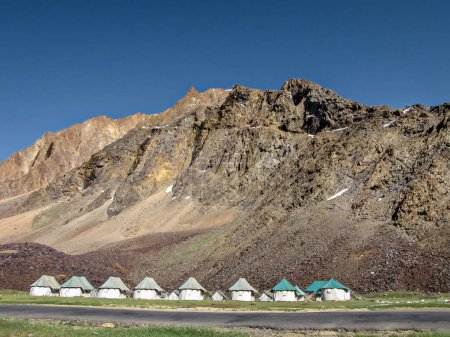 Téléchargez les photos : Tentes pour séjour sur la route hébergement à Sarchu, avec montagne et ciel en arrière-plan. - en image libre de droit