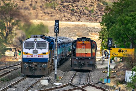 Téléchargez les photos : Daundaj, Maharashtra, Inde-3 juin 2017 : Un train de voyageurs avec locomotive EMD, en surpasse un autre avec locomotive ALCo à la gare. - en image libre de droit