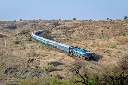 Photo for Express passenger coming out of a huge hill cutting in Ambale, Maharashtra, India. - Royalty Free Image