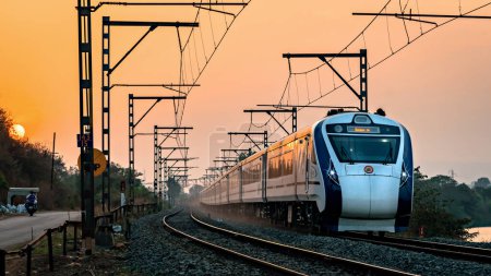 Foto de Kamshet, Maharashtra, India-21 de febrero de 2023: El primer expreso de desarrollo indígena de semi alta velocidad Vande Bharat de la India, también conocido como tren 18, junto con Sunset. - Imagen libre de derechos
