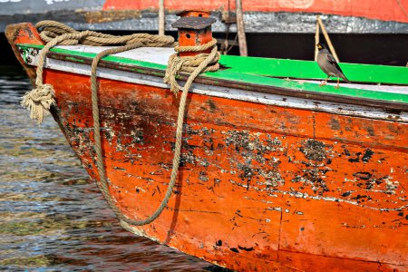 Téléchargez les photos : Image rapprochée d'un pivot de corde pour ancre et oiseau assis sur un bateau coloré dans la rivière Ganges à Varanasi. - en image libre de droit