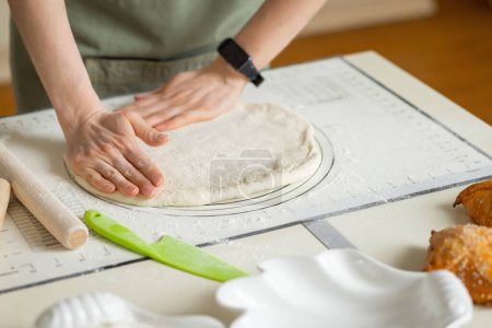 Téléchargez les photos : Mains de femme avec bracelet électronique cuisson pâtisserie sur tapis de cuisson en silicone avec des marques et des conseils. - en image libre de droit